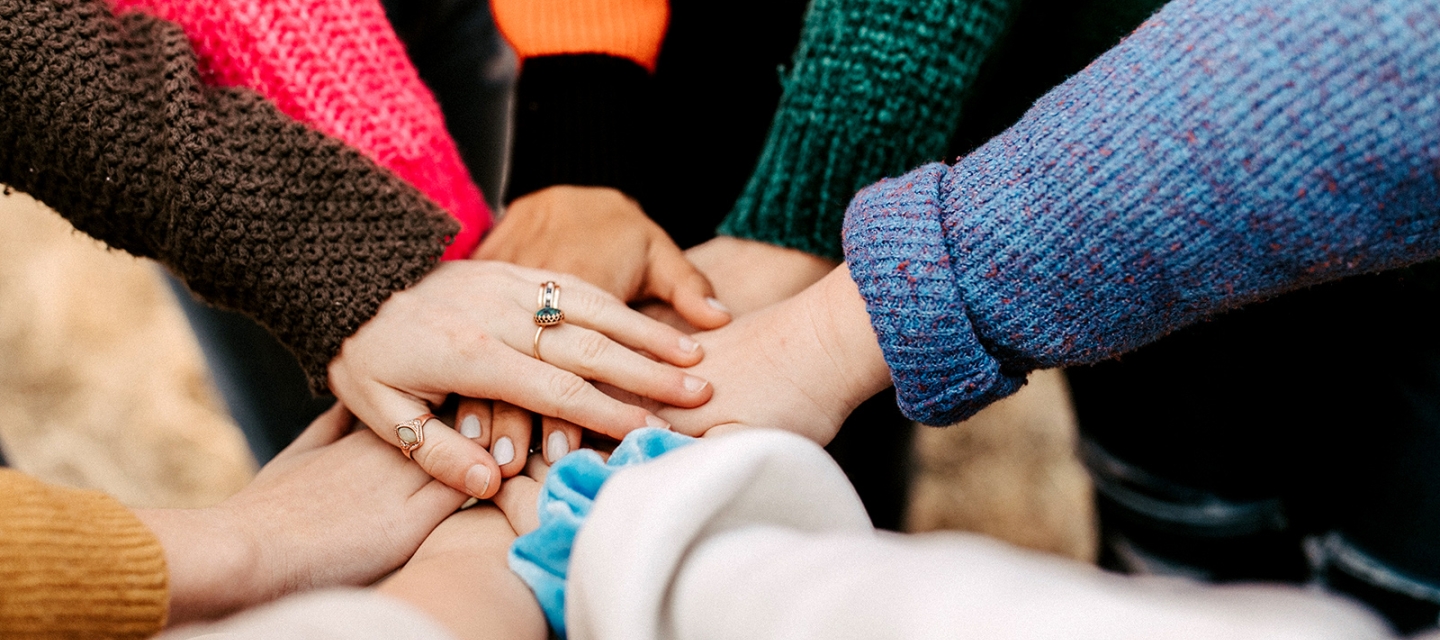 A group of hands coming together